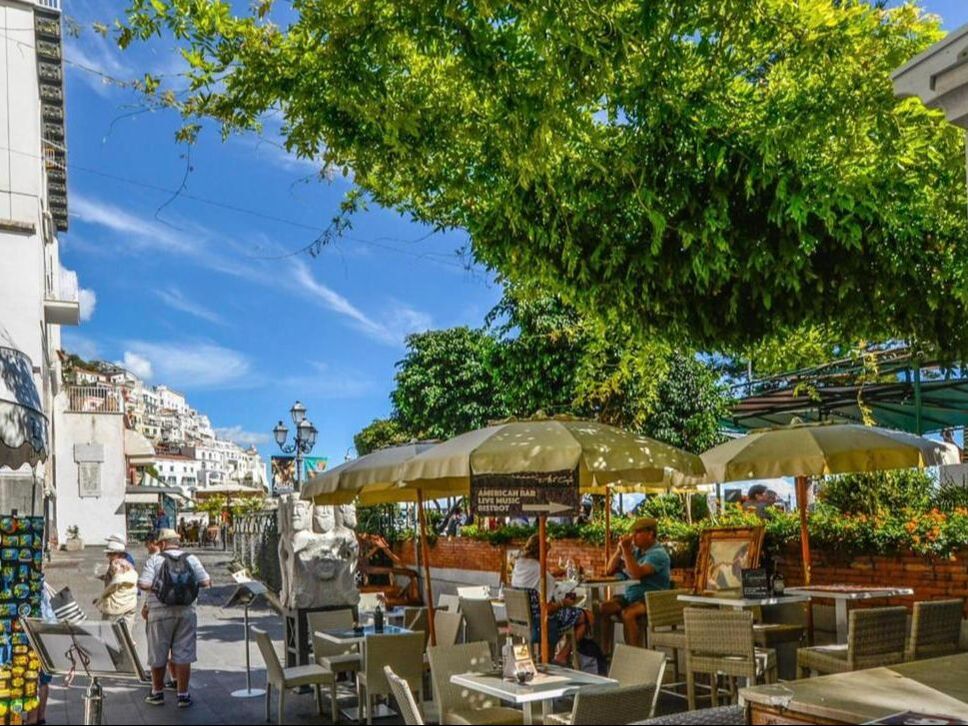 Cafe terraces under the trees in Amalfi town on the Amalfi Coast