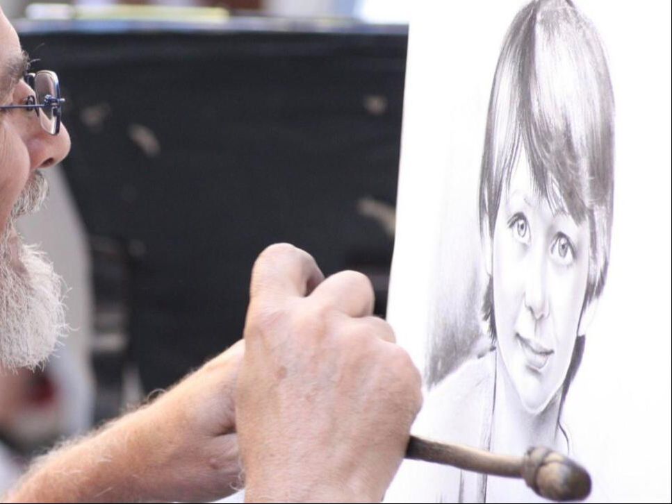 Street artist drawing a portrait in the historic center of Florence
