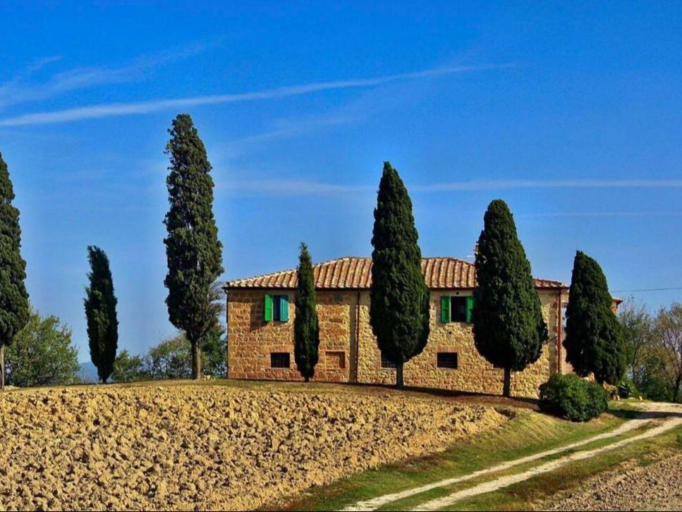 Stone farmhouse and cypress trees in the Val d'Orcia near Pienza