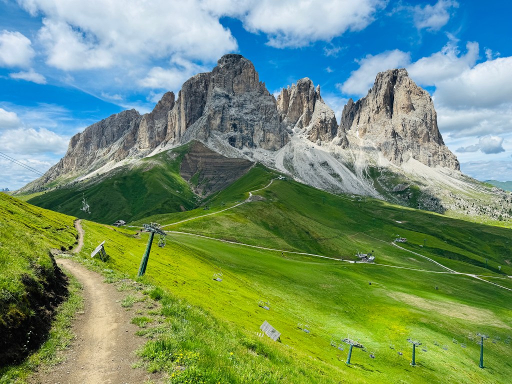 The Sassolungo peaks above green meadows in Val di Fassa, the Dolomites